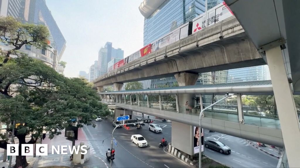Picture shows a train going past above a busy road in Thailand