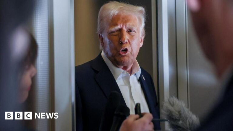 President Donald Trump speaks into two microphones in the doorway of Air Force One
