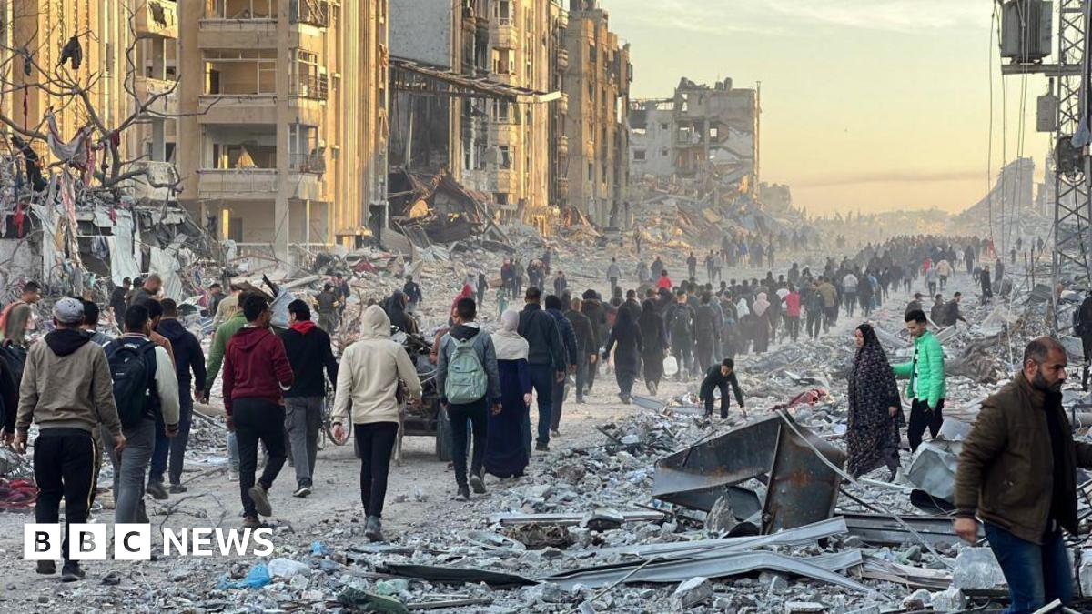 Palestinians in Jabalia walk among debris as they return to their houses after the announcement of ceasefire and hostage-prisoner swap deal between Hamas and Israel