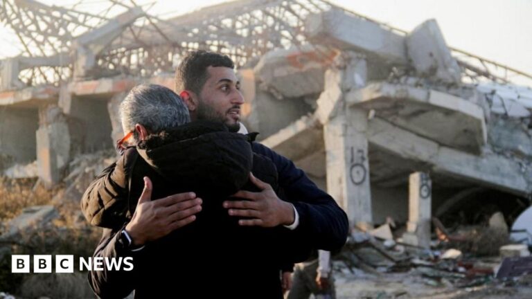 Palestinians returning to their homes hug in front of the remains of a building in Gaza City (27/01/25)