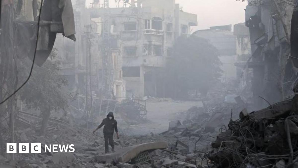 A man walks through the rubble of buildings destroyed in Israeli air strikes at Bureij refugee camp, in central Gaza (12 January 2025)