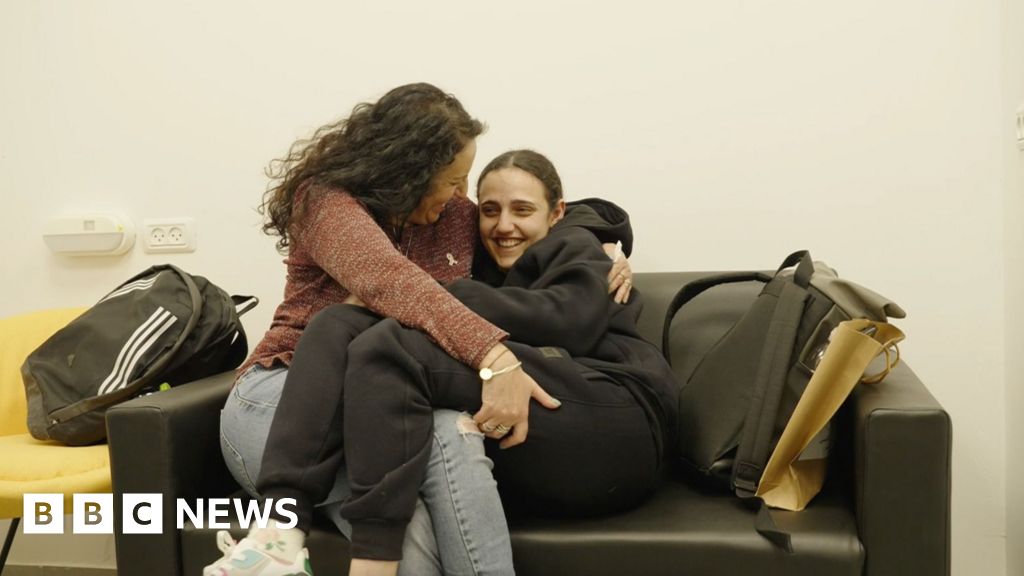Romi Gonen hugs her mother, Meirav, on a sofa after her release