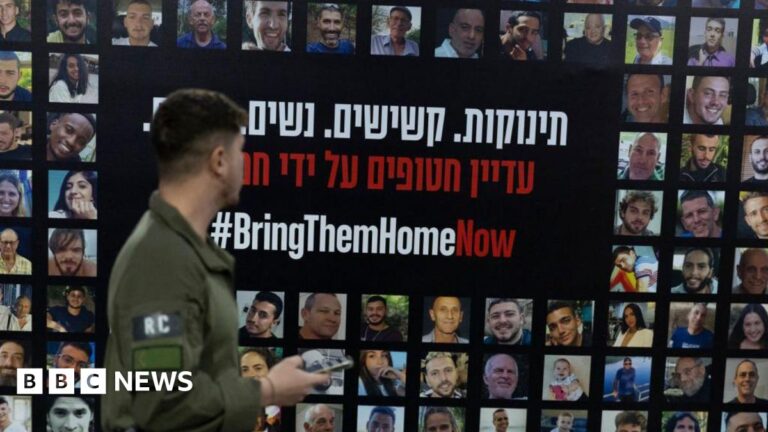 An Israeli soldier passes by a wall covered with photos of hostages held by Hamas in Gaza, at Tel Aviv train station, Israel (14 January 2025)