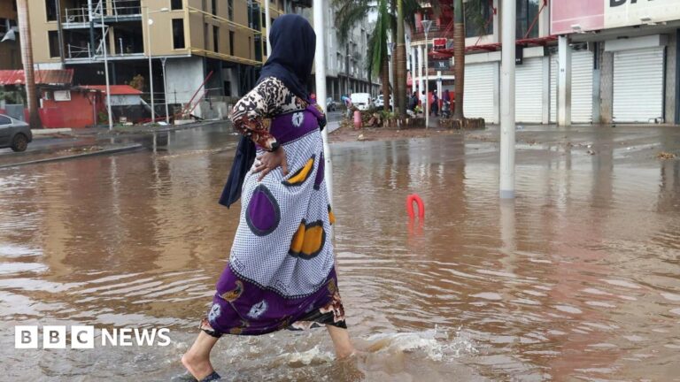 A person walks in a flooded street after heavy rains in the aftermath of Cyclone Chido, in Mamoudzou, Mayotte, France, 19 December 2024