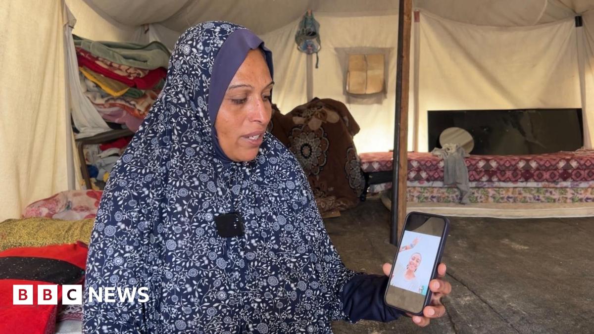 Lina al-Dabah shows photo of her dead daughter Aya on a mobile phone