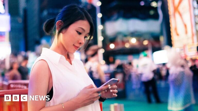 A woman in a white sleeveless top stands in New York City