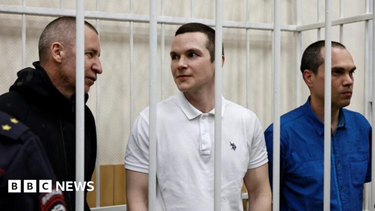 The three lawyers stand behind bars in a courtroom in the town of Petushki in the Vladimir Region of Russia on January 17, 2025