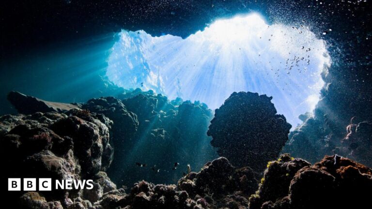 Bubbles, rocks and beams of sunlight beneath the ocean