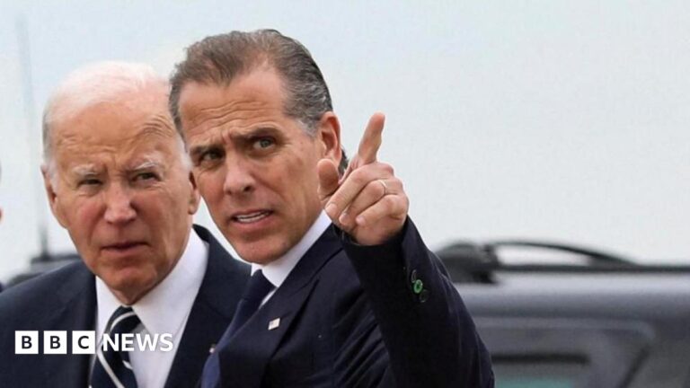 US President Joe Biden stands with his son Hunter Biden, who is pointing a finger at something off frame.