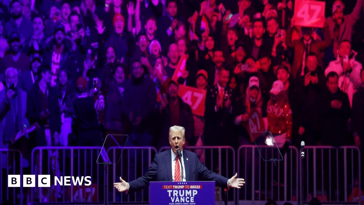 A man holds up a red Trump flag at the president-elect