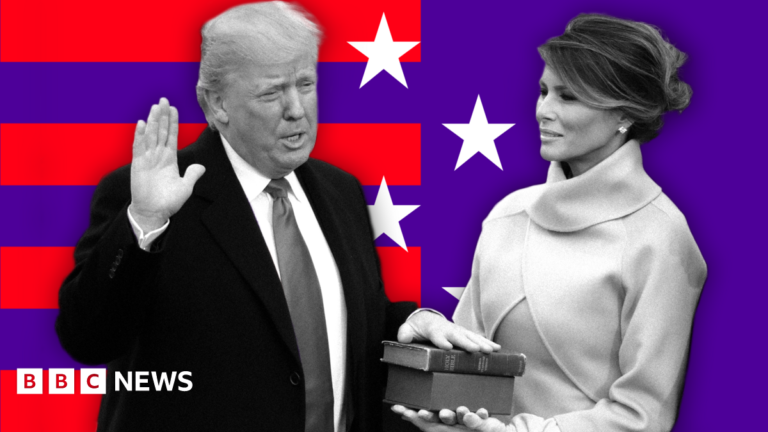 Donald Trump, dressed in a suit and tie, places his hand on a Bible his wife Melania Trump is holding. They are standing before a background of red stripes and white stars on a purple background.