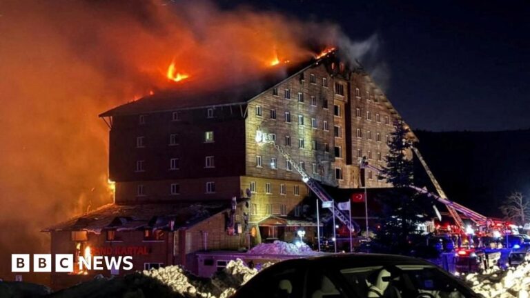 Bedsheets dangle from an upper floor of the Turkish hotel where dozens of guests died in a fire
