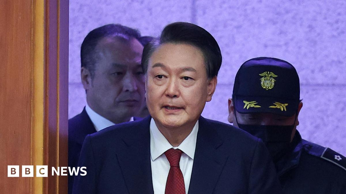 South Korea’s impeached President Yoon Suk Yeol arrives for his impeachment trial dressed in a dark blazer, red tie and white shirt.