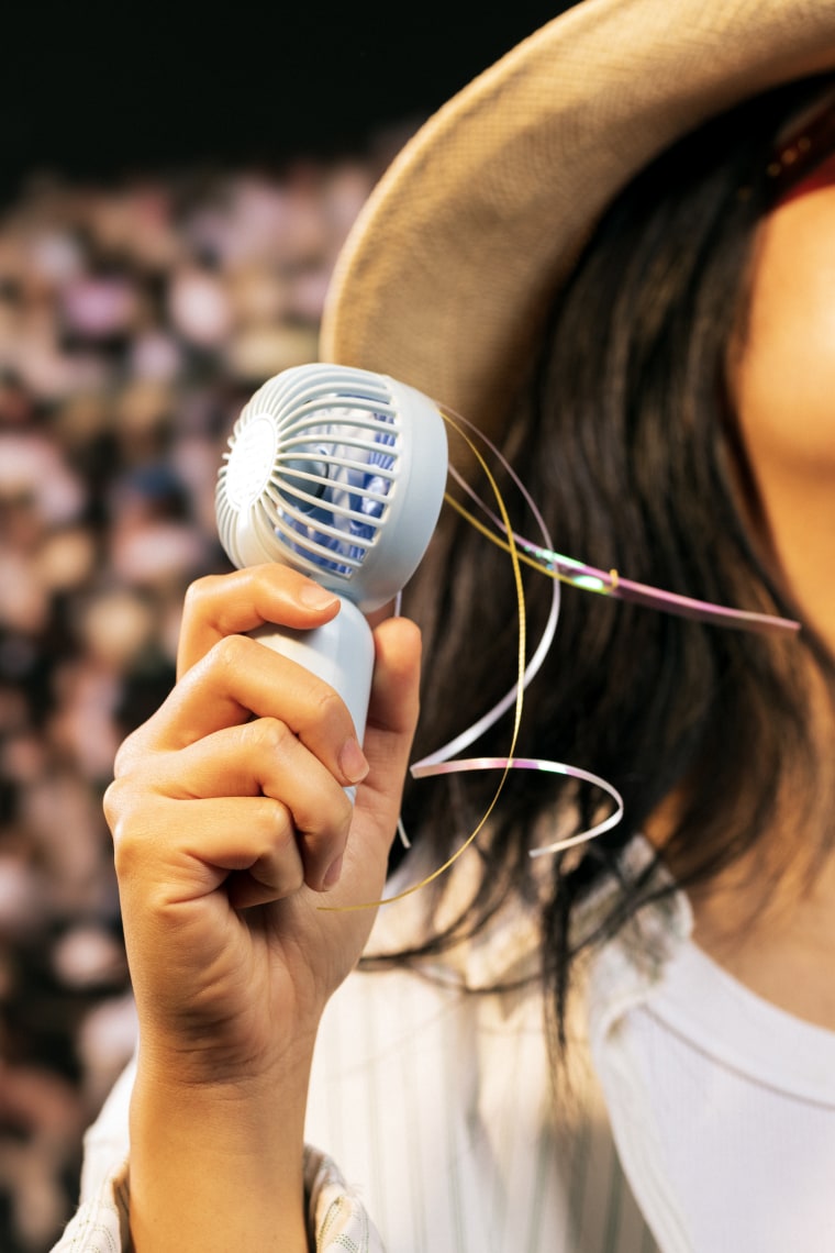 Women holding a portable fan
