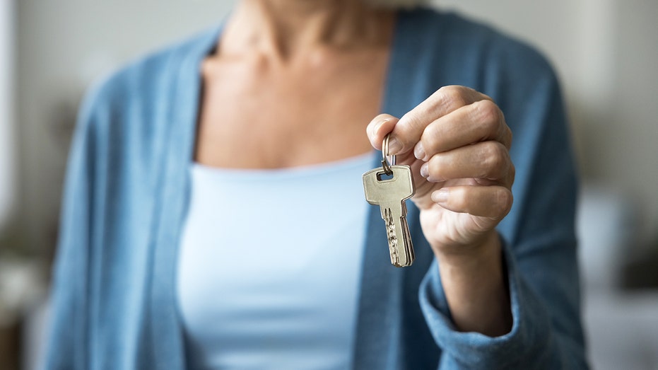 The old woman holds the set of button on her left side