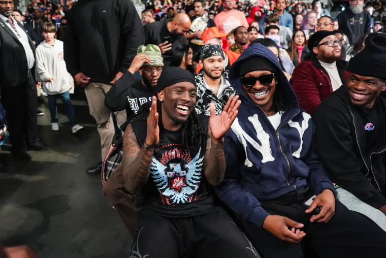 The cenat wood sit next to Dennis in the audience of the game