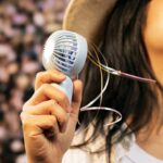 Women holding a portable fan