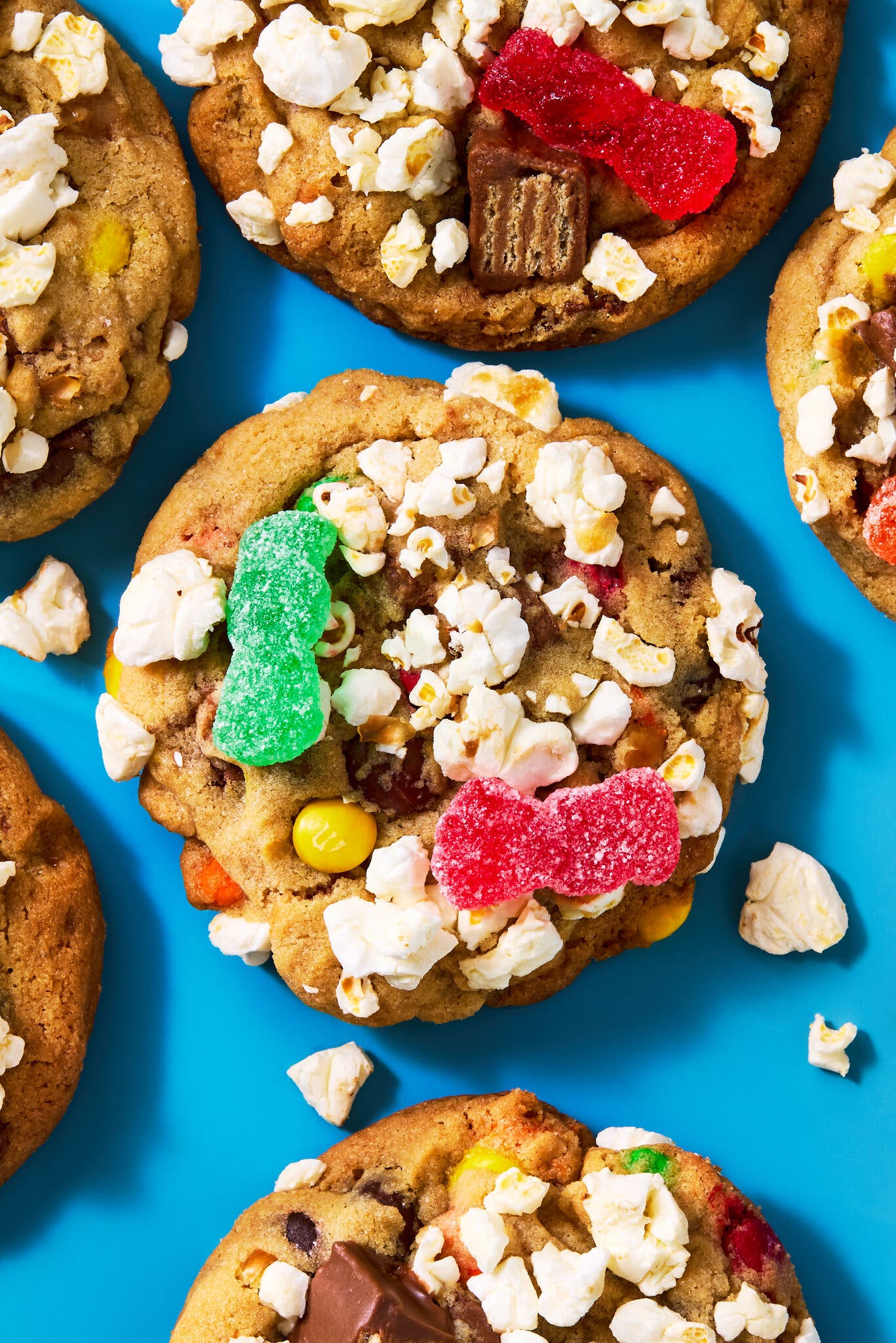 Top view of a half-dozen half-dozen cookies topped with candy and popcorn.